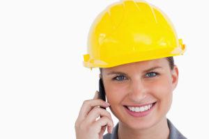 Close up of smiling female architect on her cellphone against a white background